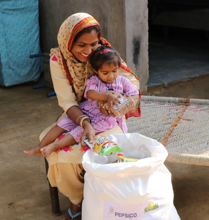 Mother and daughter looking at contents of PepsiCo dry rations kit